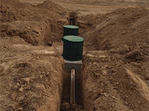 Septic system access risers visible in an open trench Septic system access risers visible in an open trench