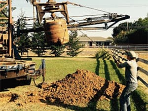 Precise setup of drilling equipment before operation Technician guiding drilling equipment into position at a job site