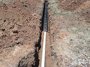 Installation of septic pipes in an excavated trench Septic pipes being installed in an excavated trench