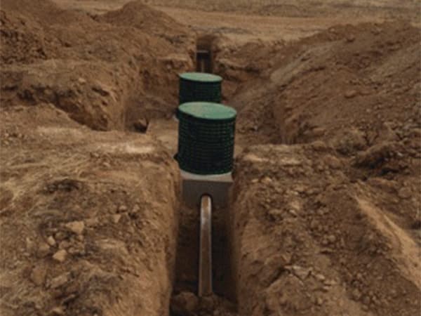 Septic system access risers visible in an open trench Septic system access risers visible in an open trench