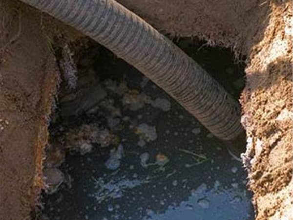 Septic tank pumping hose removing waste during routine cleaning Septic tank pumping hose removing waste during routine cleaning