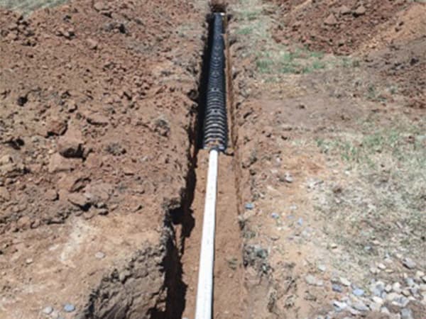 Installation of septic pipes in an excavated trench Septic pipes being installed in an excavated trench